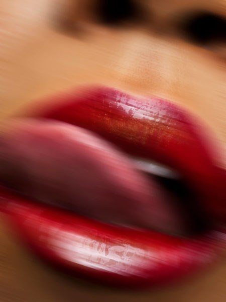 A model with red lips licking the lips by chris singer